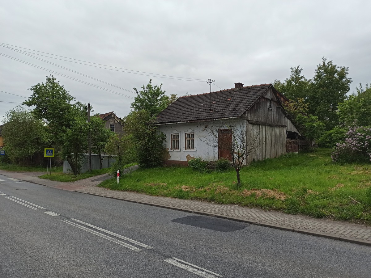 Stary dom a za nim budynek z napisem "Scześć Boże" Stary dom a za nim budynek z napisem "Scześć Boże"